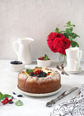 Homemade german cheesecake kasekuchen with berries on beautiful plate on table. Natural light, selective focus.