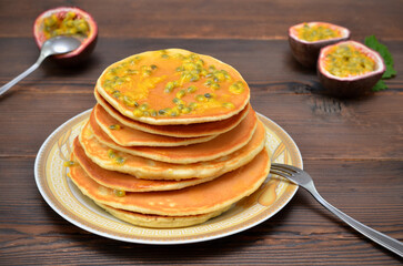 appetizing pancakes with passion fruit on a plate close-up