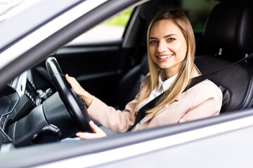 Fototapeta na wymiar Young beautiful smiling woman fass belt and driving a car.
