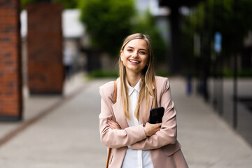 Business woman standing outdoor near corporate office building hands folded on city street