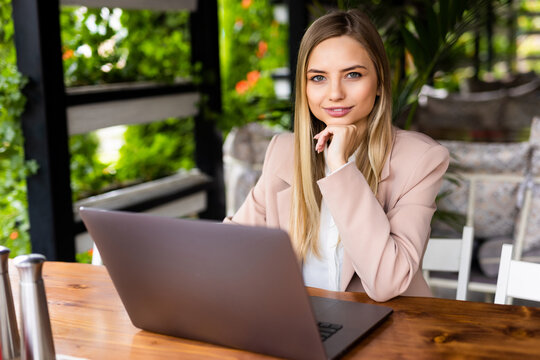 Young woman siting at cafe working on laptop. Freelance concept