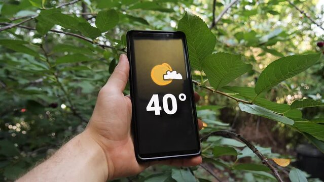 Thermometer marking 40 degrees celsius High Temperature show on Mobile Screen in hot summer. Climate change leads to more extreme weather event in Europe. Red heat warnings in Hungary. Green concept.