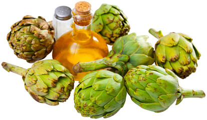 Obraz premium Bunch of artichokes placed over white background with saltcellar and glass oil bottle. Isolated over white background