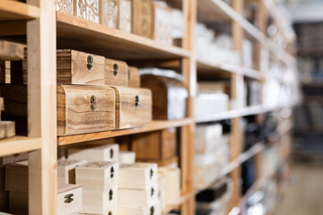 Closeup of various decorative wooden jewelry storage caskets displayed on shelves for sale in home...