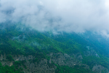 gloomy mountain landscape, wooded slopes covered with rain clouds