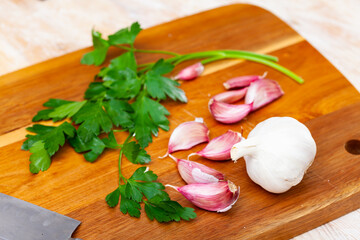 Parsley and garlic on wooden board. Preparing food concept.