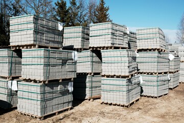 Cobblestones pallets for paving under construction laying outside. Concrete blocks for installing new roadway. Stone blocks pile for renovation road.
