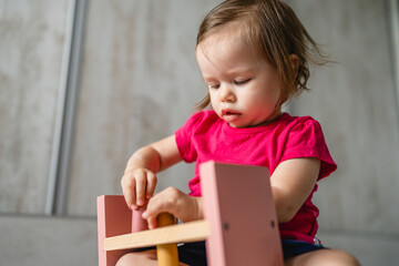 one child small caucasian girl little toddler playing with educational toys at home childhood and growing up early development concept copy space front view