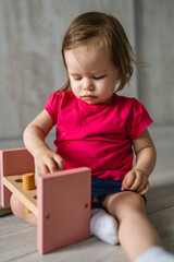 one child small caucasian girl little toddler playing with educational toys at home childhood and growing up early development concept copy space front view