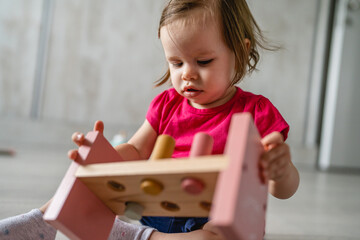 one child small caucasian girl little toddler playing with educational toys at home childhood and growing up early development concept copy space front view