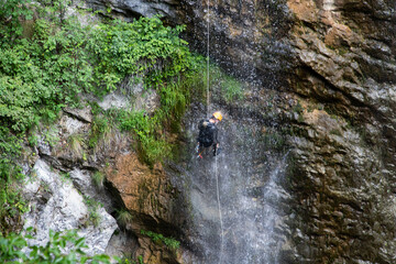 alpinist climbing down a waterfall