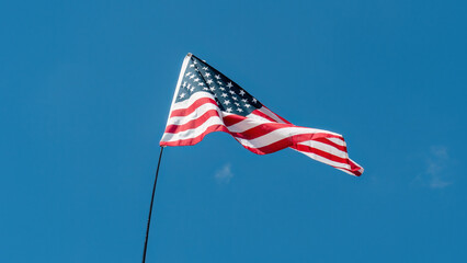 American flag waving against blue sky