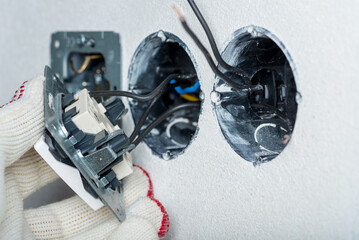 The electrician installs the electrical socket and switch.European high voltage 230V standard. - 516238003