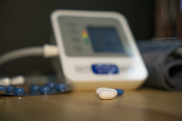 Blood pressure monitor and pills on the table.