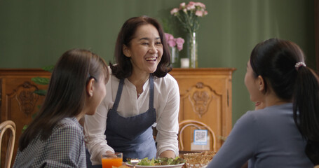 Adult SME owner work at busy small cafe bar pub on cozy day carry plate tray for group asia people friend party at vegan shop. Enjoy talk order fresh menu eat meal drink fine dish diet salad bowl.