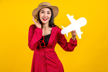 Young adult asia people beauty woman holding white airplane paper smile laugh in yellow isolated background ready for summer holiday travel fly safe plan concept. Airline tourism marketing campaign.