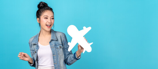 Young adult asia people beauty woman holding white airplane paper smile laugh in blue isolated background ready for holiday travel fly safe plan concept. Airline tourism marketing campaign.