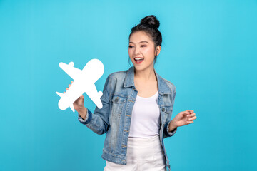 Young adult asia people beauty woman holding white airplane paper smile laugh in blue isolated background ready for holiday travel fly safe plan concept. Airline tourism marketing campaign.