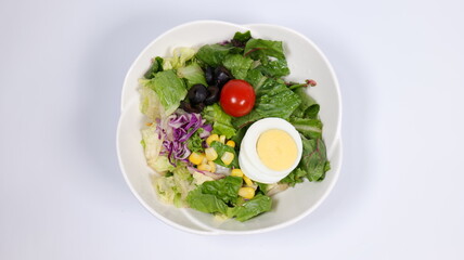 Salad topped with tomatoes and eggs