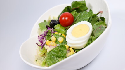 Salad topped with tomatoes and eggs