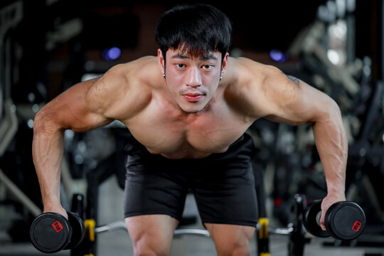 Photo of muscular man in gym on  blurred background. Fitness and healthy lifestyle concept. Copy space.
