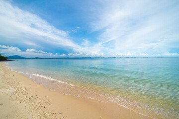 Sea beach wave splash on white sand beach against blue sky cloud