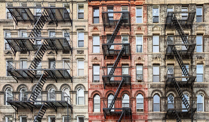 Exterior view of New York City style architecture apartment building with windows and fire escapes