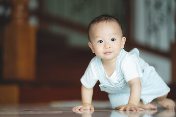 Cute little toddler trying and learning to crawl at home