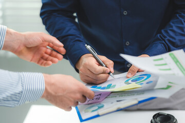 Hands of young male in formal clothing signing documents with employees consultant