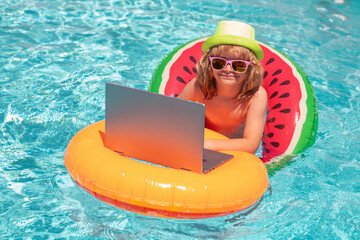 Funny kids summer face. Kid boy relaxing in the pool, using laptop computer in summer water. Child online study or working on tropical sea beach. Technology for life concept.