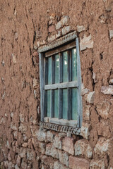 The texture of the clay wall of an old house with window