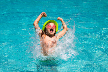 Kid splashing in swimming pool. Little child boy in swimming pool swim on summer vacation. Beach...