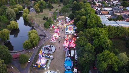 aerial footage of funfair where people are having enjoy with scary rides at Local Public Park