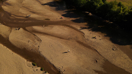 Ice cream peddler walking on dry river banks, Cordoba in Argentina. Aerial top-down view