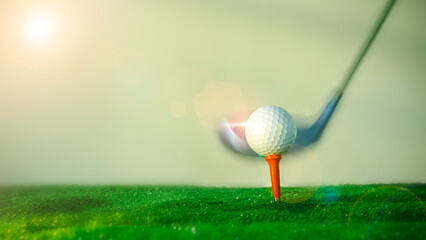 Close-up shot of a golf ball on the hitting platform. Golf ball on red hitting platform on beautiful green grass with morning sun. Sports    their holidays health. Sports and health concepts.
