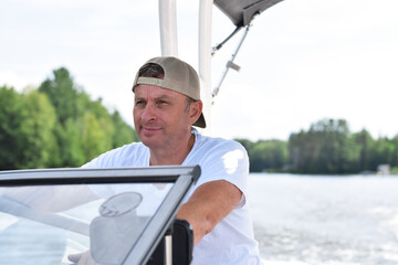 Middle aged man driving boat on a lake