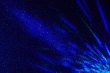 On a dark blue gradient background in fine grain, multi-colored long and short glare of light