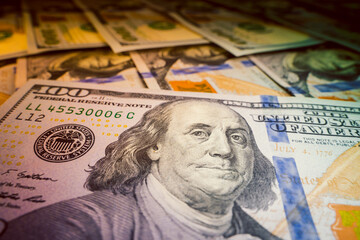 Close-up beautiful clean new one hundred dollar bill lies on other one hundred dollar bills