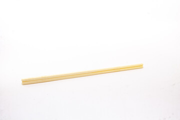 a pair of chopsticks on an isolated white background. Chopsticks are cutlery originating from East Asia, in the form of two equal-length wooden sticks held between the fingers of one hand. 