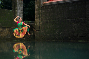 Bharatanatyam dancer posing in front of the beautiful lake.