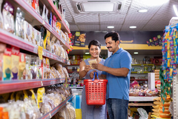 Happy couple shopping for groceries at the supermarket