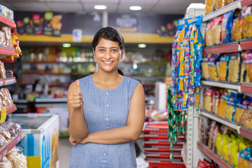 Happy Indian woman showing thumbs up at supermarket