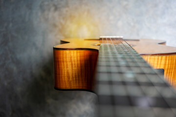 Nylon classical guitar neck and body on concrete background.