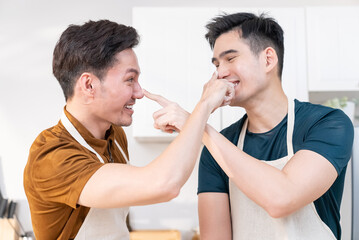 Asian young LGBTQ male gay couple enjoy bake bakery in kitchen at home.