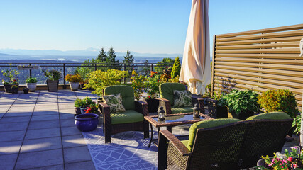 Outdoor furniture and umbrella on rooftop patio garden overlooking BC  valley.
