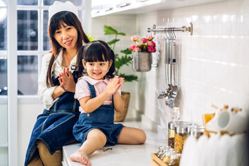 Portrait of enjoy happy love asian family mother and little asian girls child smiling and preparation of cooking breakfast together in the kitchen at home