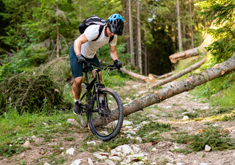 Professional mountain bike cyclist riding a trail in the forest. Active healthy lifestyle. Extreme...