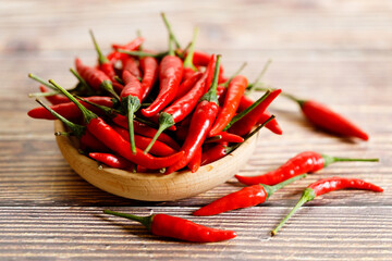 Fresh red chili peppers in wooden bowl.