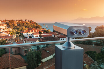 Tourist optical telescope on the observation deck viewpoint overlooking the old resort town with...