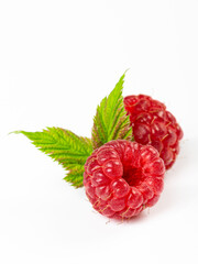 Ripe raspberries with leaves isolated on white background
